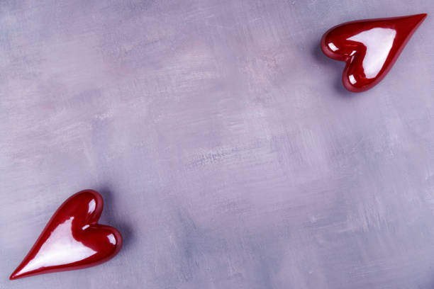 istock Porcelain hearts in red and white, artfully scattered on a gray concrete surface, representing love for Valentine's Day celebration 2185201999