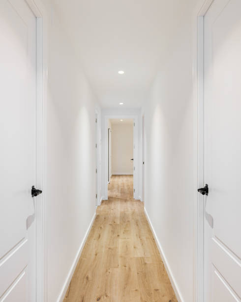 istock Long narrow straight corridor with doors on the left and right in a mini hotel after renovation. Concept of a cozy hotel and rooms for vacation or business trip. Copyspace 2185202503