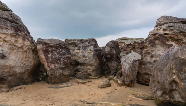 istock Massive rocks with weathered surfaces and unusual shapes under a gray sky, evoking an ancient world of nature 2185203615