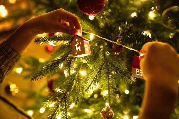 Close-up of a little boy's hands decorating Christmas tree