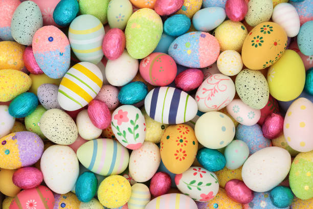 Easter egg background with large collection of decorated and foil wrapped eggs. Edible sweet colorful food design for holiday season for greeting card.