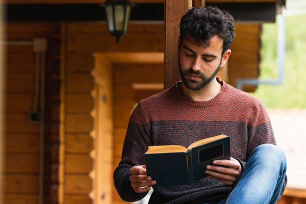 istock Pensive man chilling on terrace with book 2185206882