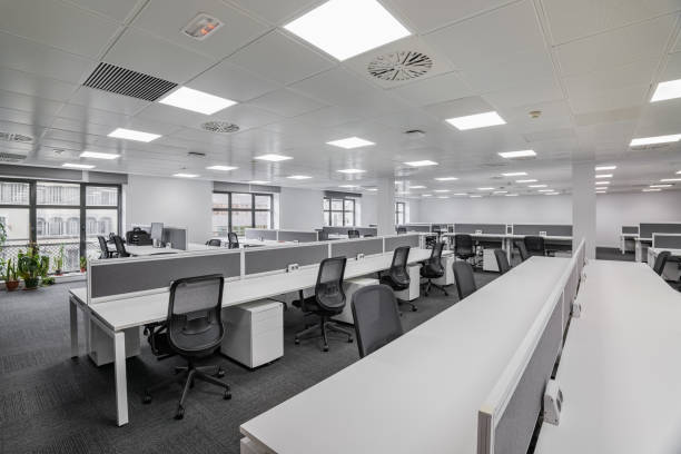 istock Spacious empty office with gray floor and tables with chairs awaiting relocation call center of taxi services. The concept of creating new jobs in the city and a modern and comfortable workplace 2185207578