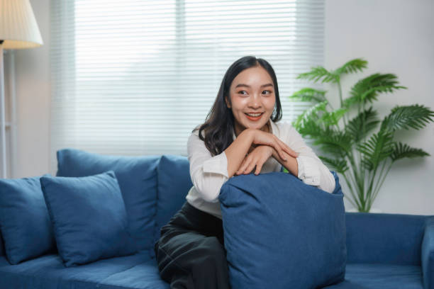 istock Asian businesswoman finds peace and relaxation while smiling on a comfortable sofa in her modern living room 2185207961
