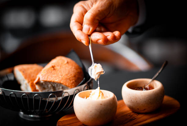 istock Hand Spreading Butter on Fresh Bread in Elegant Restaurant Setting 2185208828