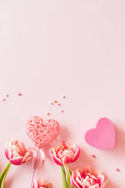 istock Pink tulips and hearts on a light pink background 2185209738