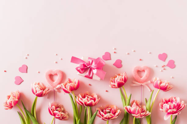 istock Pink tulips and hearts, gift box with ribbon on light pink background 2185209745