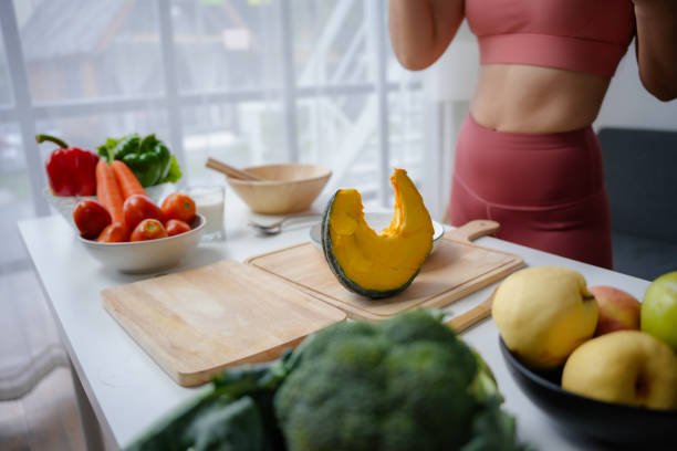 istock Woman is preparing a healthy meal with various vegetables including a pumpkin on a kitchen table 2185209959