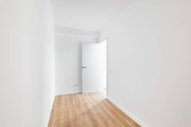 istock Empty narrow room with laminate flooring and newly painted white wall in refurbished apartment with corridor leading to other rooms. Repair and construction concept. 2185210095