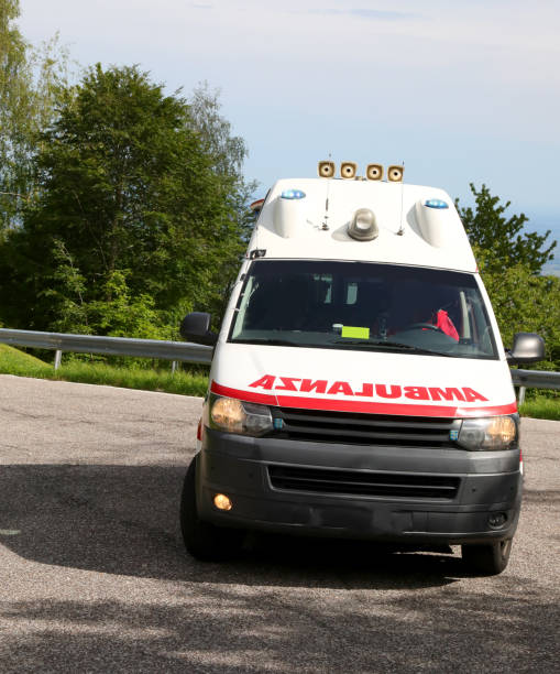 istock van with text reading AMBULANCE backward speeding in italian language with blue sirens flashing 2185211149