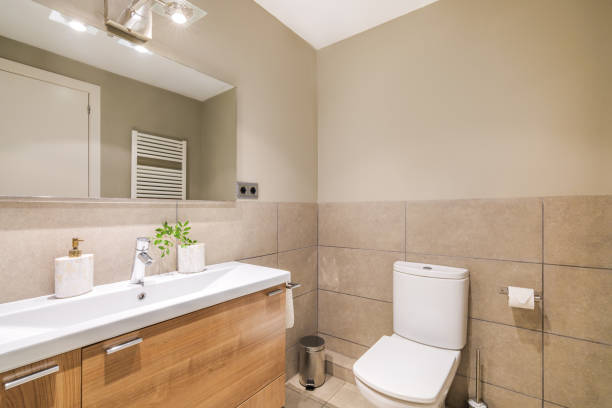 istock This elegant bathroom features a modern design with beige tiles, a spacious room, sleek sink, mirror and toilet. The neutral colors and clean lines create a serene and inviting space. 2185211351