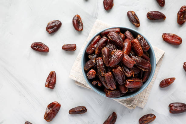 istock Pitted Organic Dates in Bowl on gray background, top view. Flat lay, overhead, from above. 2185211726