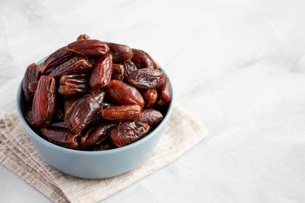 istock Pitted Organic Dates in Bowl on gray background, low angle view. Copy space. 2185211831