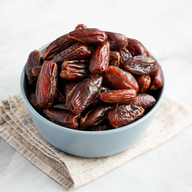 istock Pitted Organic Dates in Bowl on gray background, low angle view. 2185211854