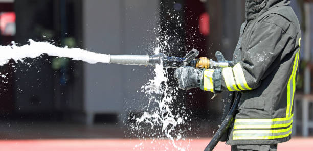 istock firefighter spraying extinguishing agent with hose during emergency 2185211950