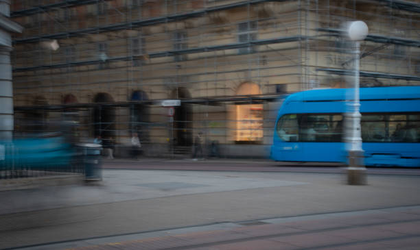 Blue tram passing by in city center with motion blur effect emphasizing on the speed . Zagreb, Croatia