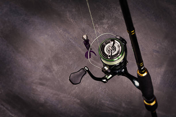Spinning rod with reel on a dark background. Copy space. Fishing background.