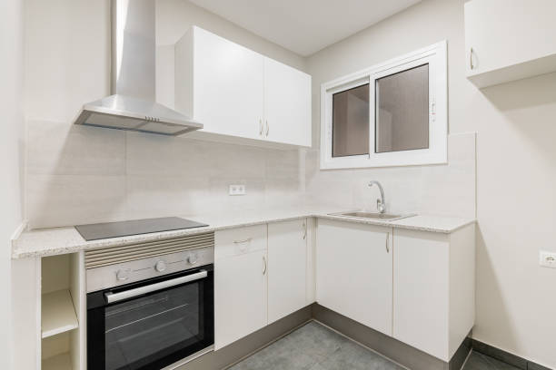 istock Light compact kitchen with stove, extractor hood and sink and window. Concept of kitchen in a small apartment. Modern minimalist design in new buildings 2185218182