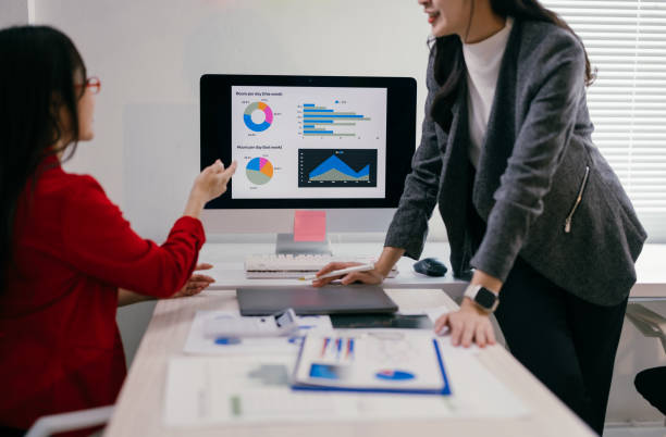 istock Two businesswomen are collaborating on a project, analyzing charts and graphs displayed on a computer screen during a productive office meeting 2185218946