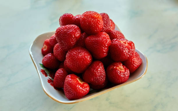 istock Juicy strawberries glisten under warm sunlight, arranged invitingly in a bowl. 2185219021
