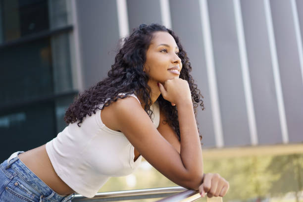 istock A young woman leans on a railing outdoors, reflecting on life while enjoying natures beauty 2185219659