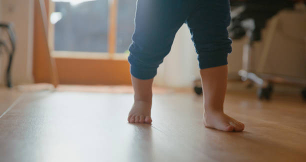 istock Barefoot Baby Boy Walking on Hardwood Floor 2185221028