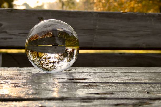 istock Crystal ball on wooden table in park during sunrise 2185222381