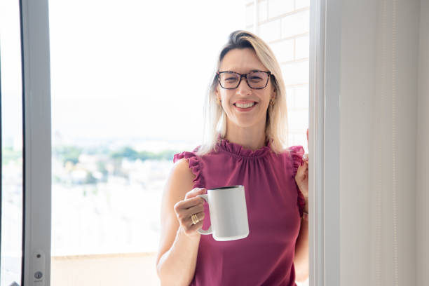 istock woman on balcony holding cup 2185224432