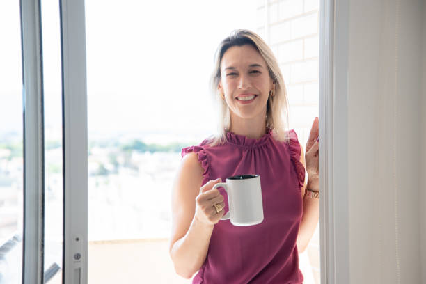istock woman on balcony holding cup 2185224437