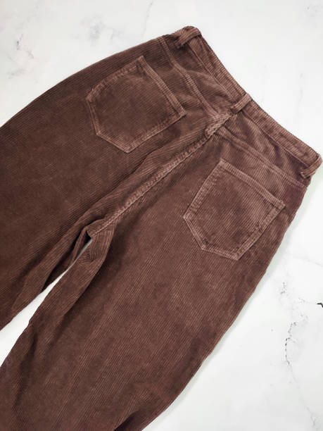 istock Brown corduroy pants back side flat lay at white marble background top view, clothes, fabric, clothing store, sewing, manufacturing, textile, fabric, pockets, high waisted trousers, wide velvet pants 2185227000