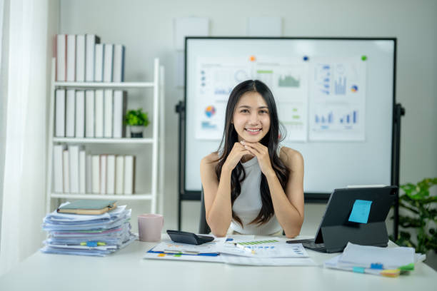 istock A woman is sitting at a desk with a white board behind her 2185228957