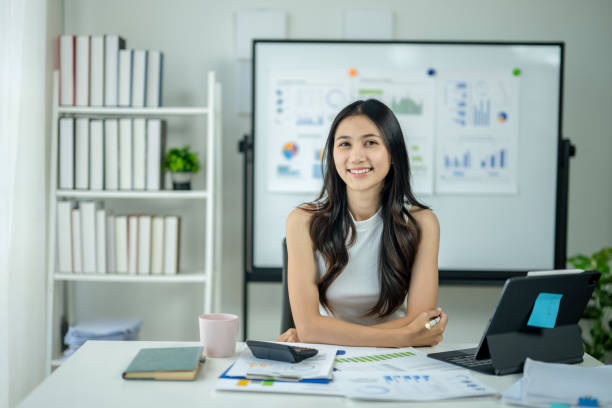 istock A woman is sitting at a desk with a white board behind her 2185228977
