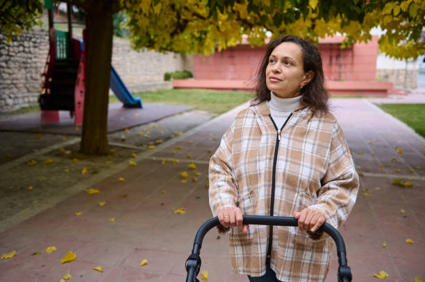 istock Woman walking in a park with a stroller in autumn 2185235162