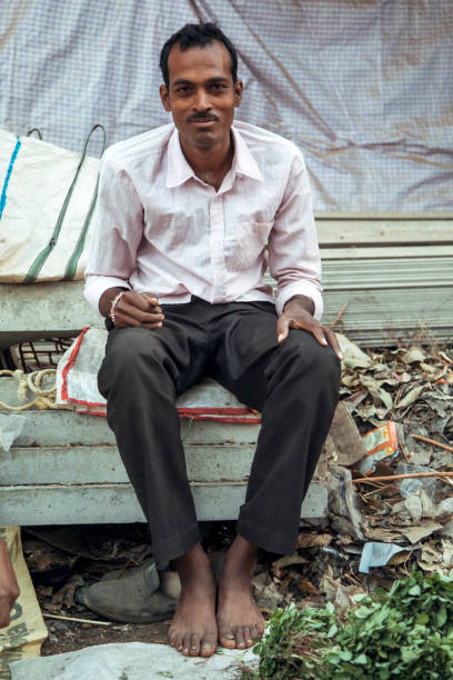 Nagaur, Rajasthan, India - Oct 12, 2011: A cobbler works as a shoe repairer on a sidewalk in a street in the town of Nagaur.