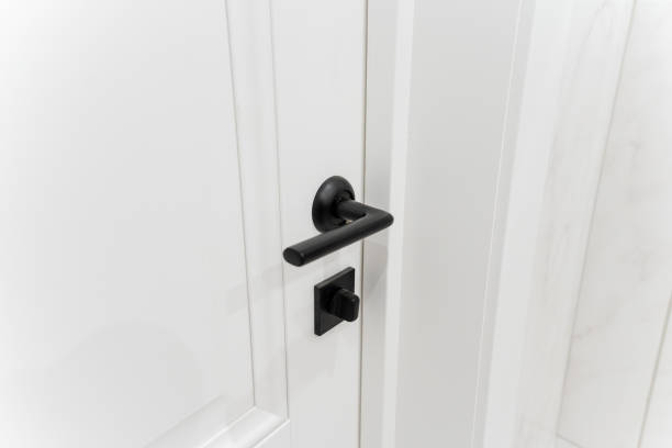 istock This is a detailed closeup photograph showing a black door handle installed on a white painted door, highlighting its design and functionality within a residential context 2185235992
