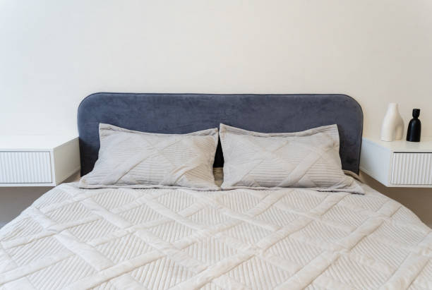 istock This stylish and contemporary bedroom features a chic gray headboard complemented by elegant, textured bedding, creating a cozy and inviting atmosphere for relaxation 2185236017