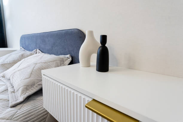 istock A modern minimalist bedroom features a stylish nightstand adorned with chic decorative vases and cozy bedding, creating an elegant and relaxing atmosphere 2185236055