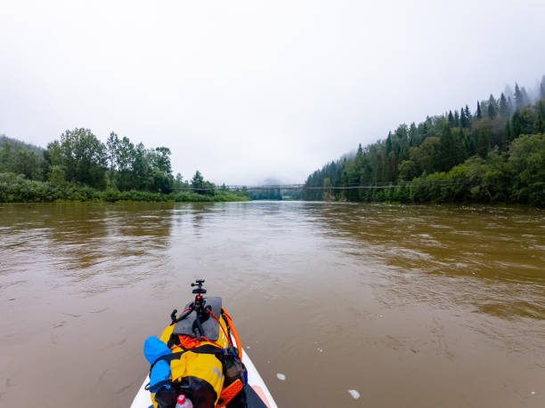 istock A person is quietly and peacefully kayaking down a gently flowing river, fully immersed in and enjoying the beautiful experience amid the vibrant, picturesque landscape surrounding them 2185236145