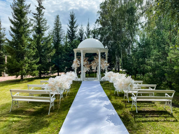 istock In a lovely park, a beautiful wedding ceremony is currently taking place, featuring a charming gazebo and inviting benches for guests to comfortably enjoy this wonderful and special event 2185236188