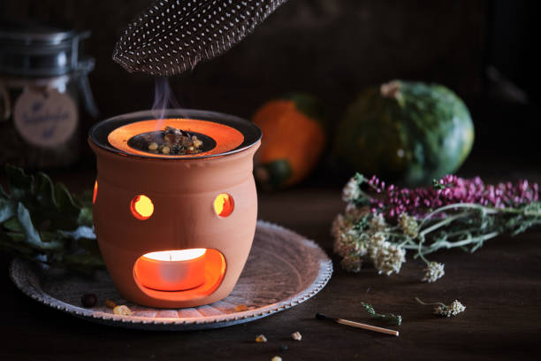 istock Burning various types of incense in an incense burner with tea light - spreading the smoke with a feather 2185238061
