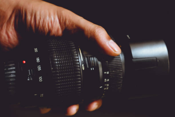 istock A person's hand holding a DSLR lens in low light 2185240070
