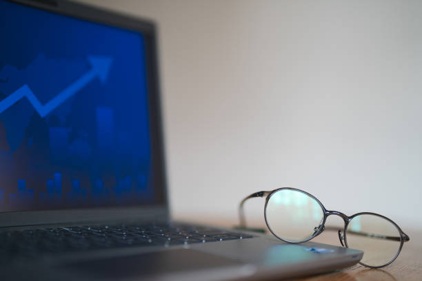 Laptop in office table with reading glasses