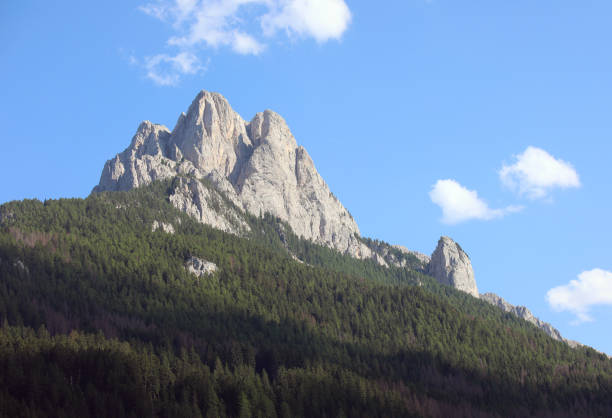 Log cabin and snowcapped Dolomite mountain in the background.