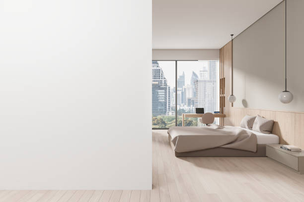 istock Modern bedroom with large blank wall for mockup and city view through window. 3D Rendering 2185251650