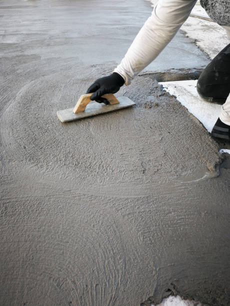 istock Bricklayer smoothes out fresh cement with a trowel. 2185251999
