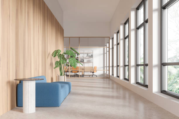 istock Modern office interior with blue sofa, wooden wall, and large windows. 3D Rendering 2185252640