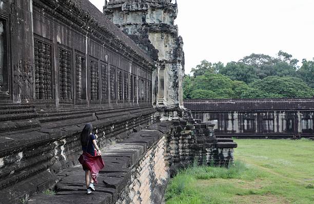 A girl tourist in traditional dress in the Angkor Wat temple - Cambodia