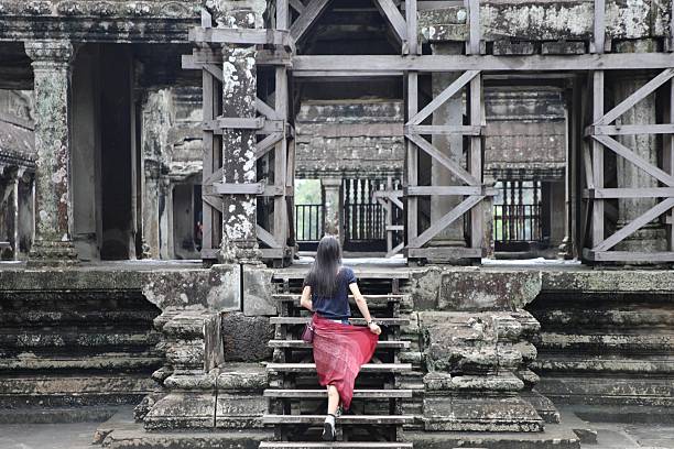 A girl tourist in traditional dress in the Angkor Wat temple - Cambodia