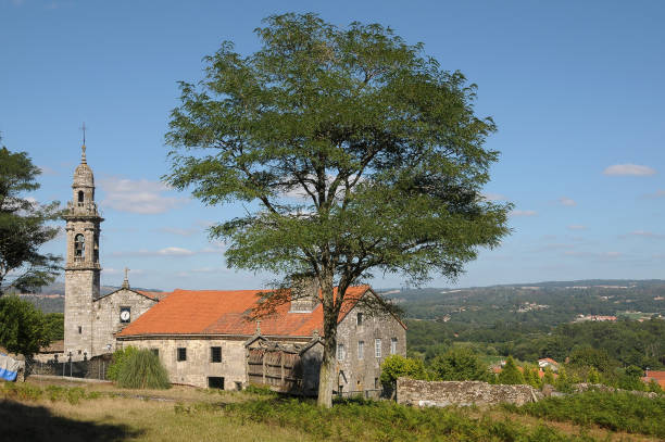 Rural landscape with an old warehouse and a granary next to a church in the agricultural area of ​​the Brión region, Galicia, Spain