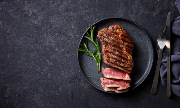 istock Beef Steak medium rare on a black plate. Dark background. Top view. Copy space. 2185256025